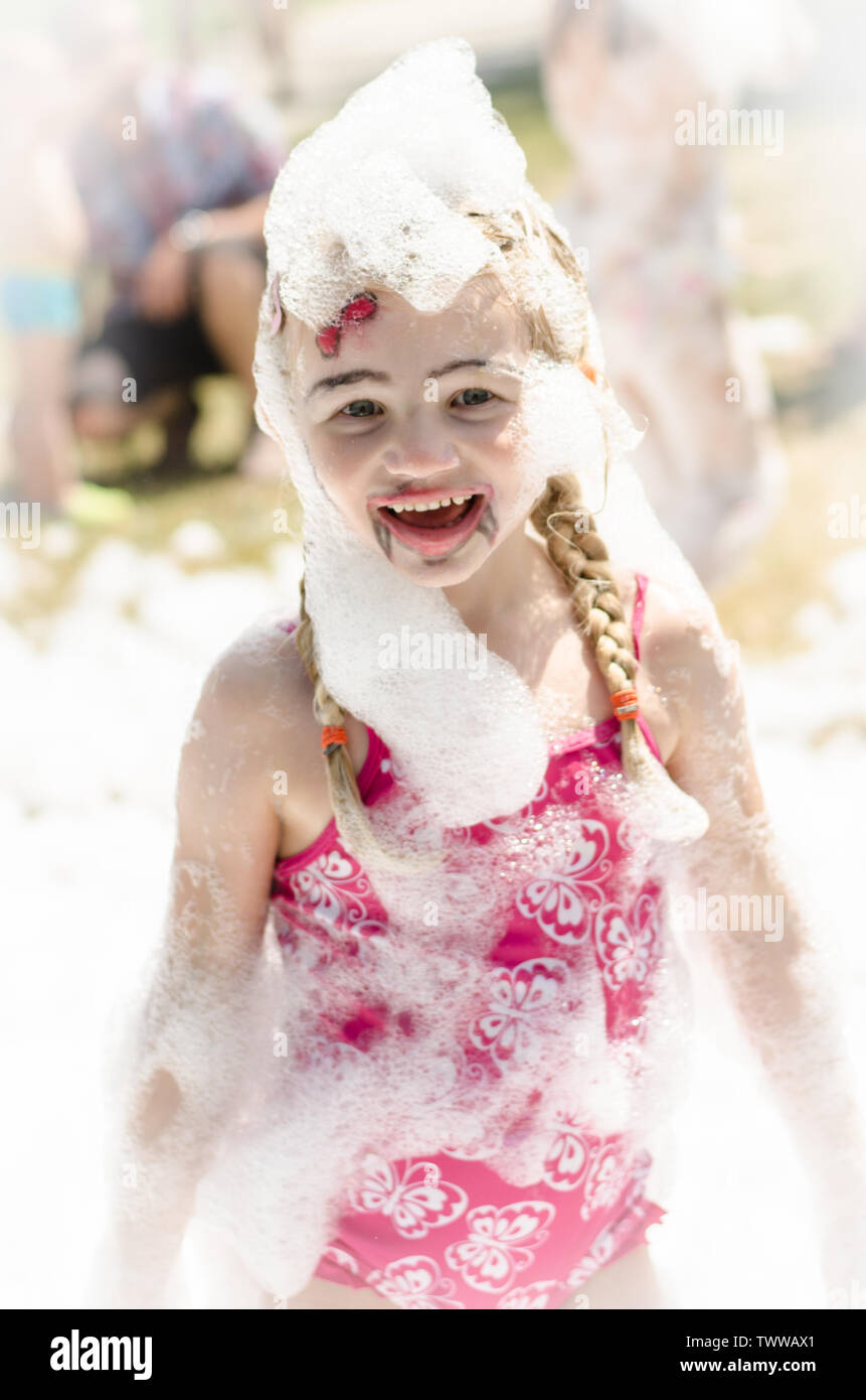 happy blond girl enjoying foam party Stock Photo Alamy