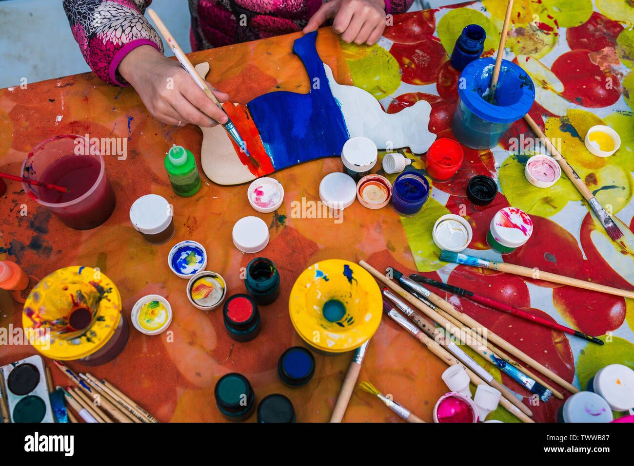 Russia, Yaroslavl city - May 4, 2019: The child holds a brush. Coloring a wooden board. Creative studio or drawing lesson. Training Stock Photo
