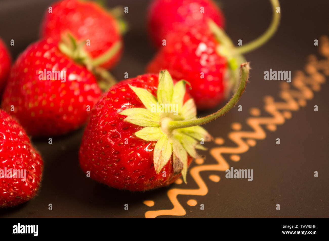 fresh ripe berries strawberries on black ceramic plate Stock Photo - Alamy
