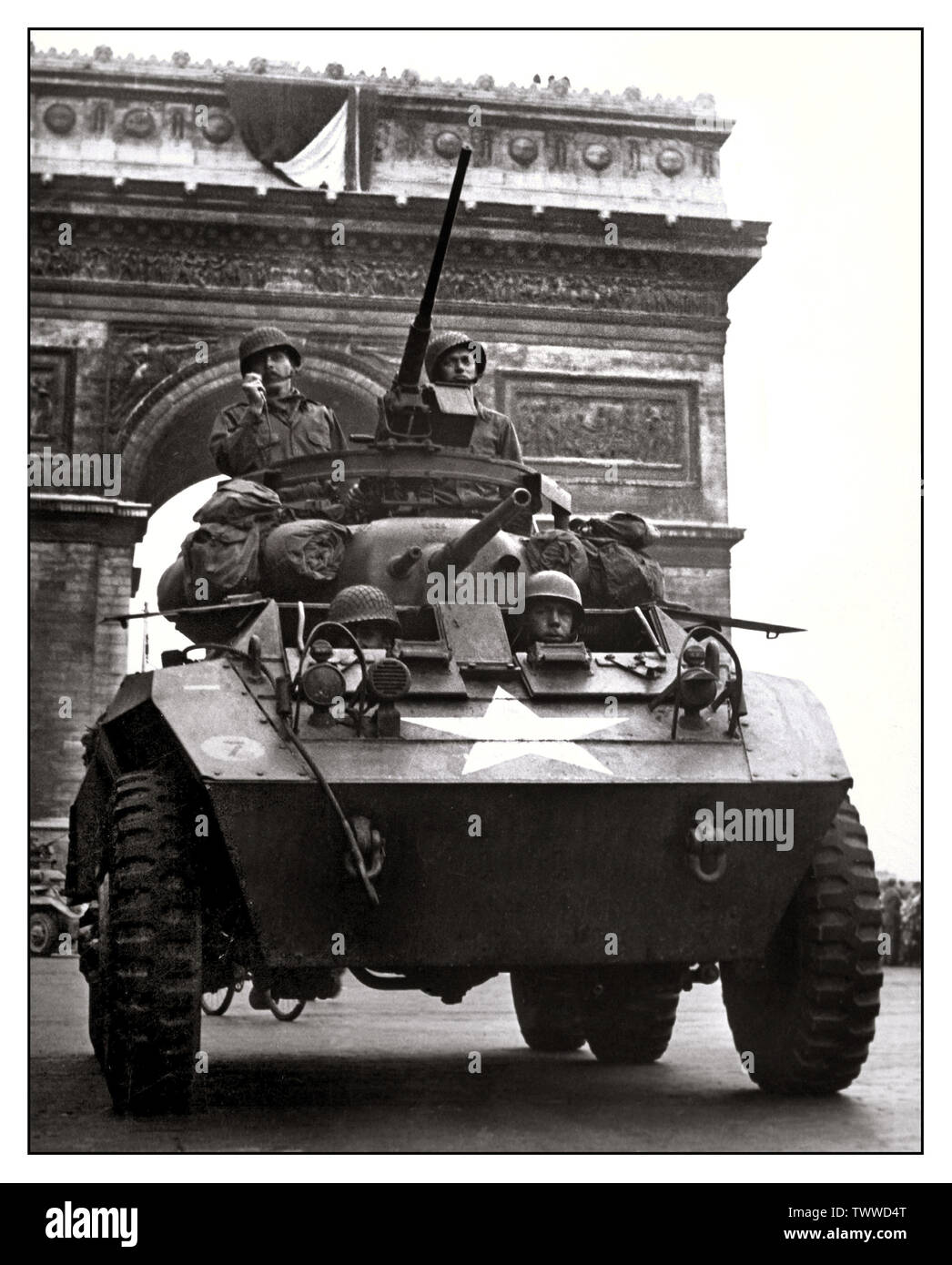 PARIS LIBERATION Vintage WW2 image of American soldiers in armoured vehicle during the liberation of Paris France the Tricolor flying from the Arc de Triomphe American armoured vehicle in Paris, August 1944. Stock Photo