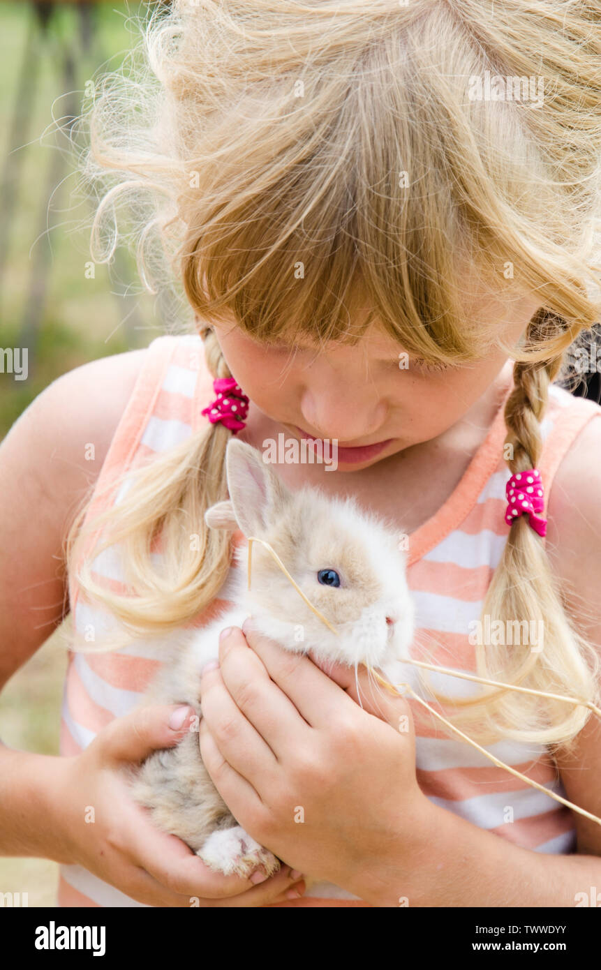 beautiful blond girl holding young bunny rabbit Stock Photo