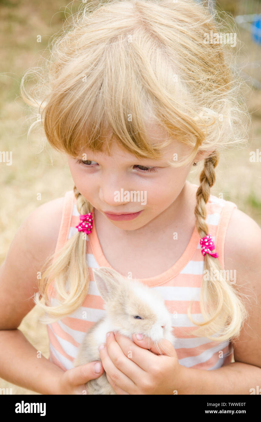 adorable caucasian blond girl holding little bunny rabbit Stock Photo