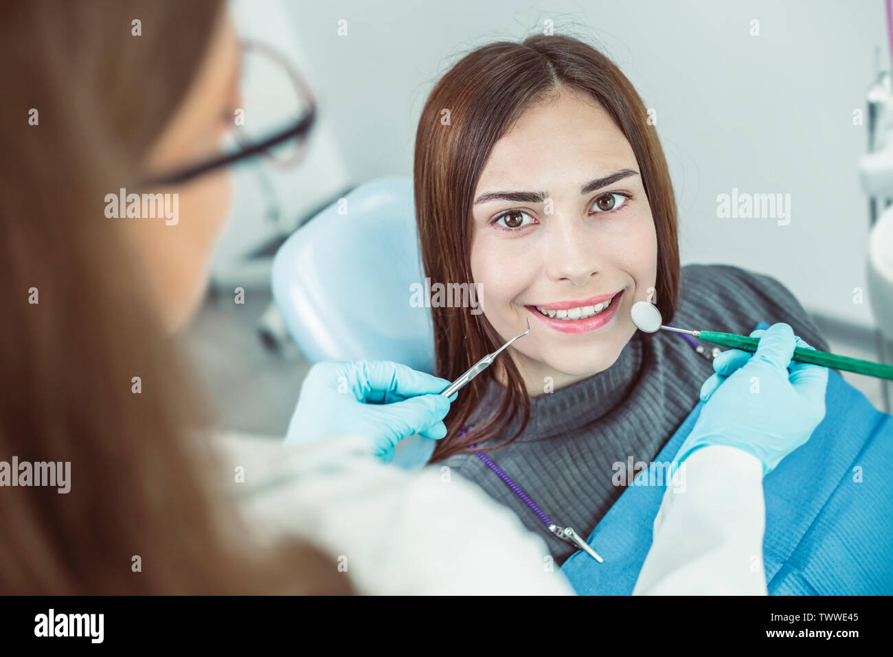 Smiling girl treats teeth while sitting in the dental chair at the doctor. Stock Photo