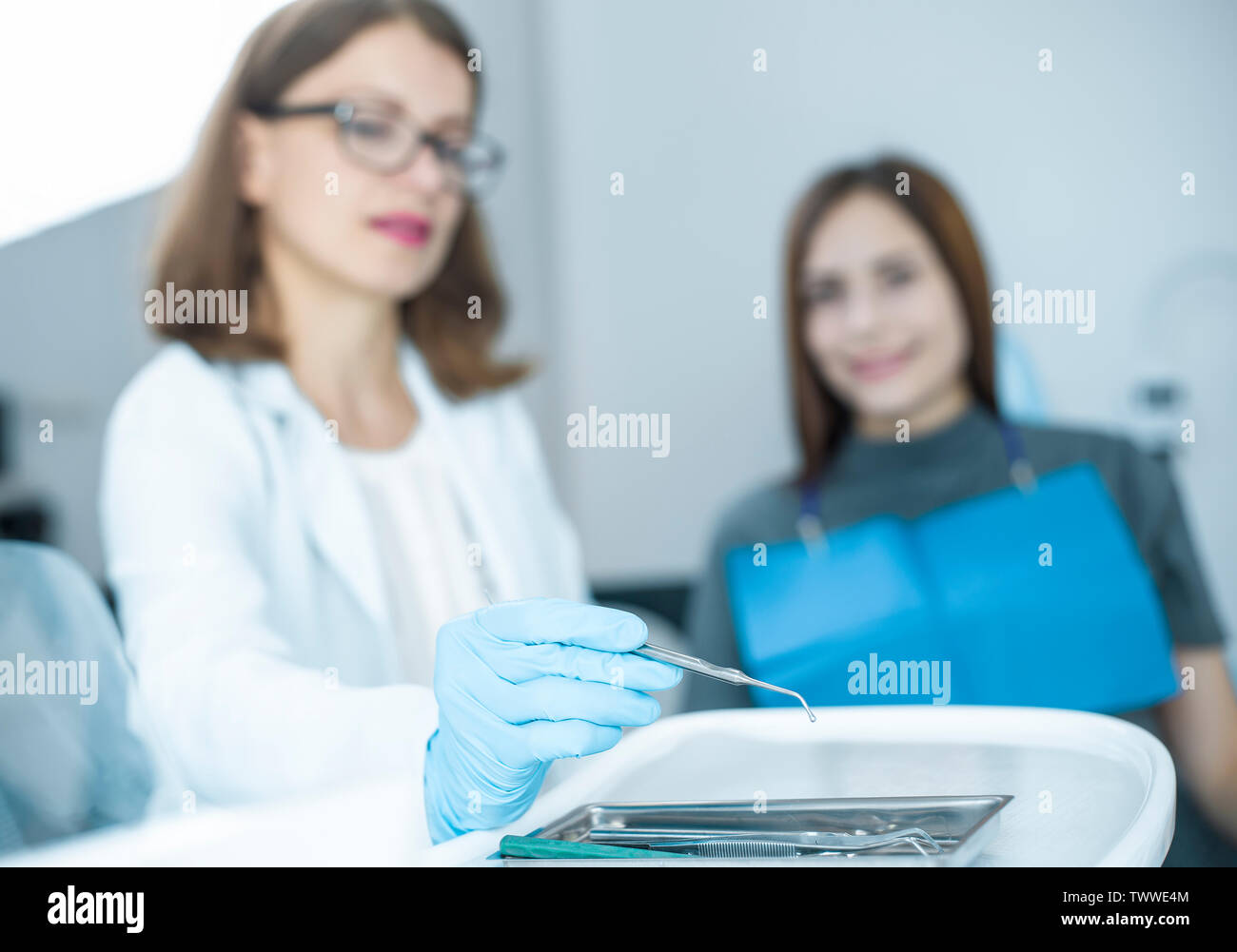 Woman doctor dentist takes a medical instrument. Stock Photo