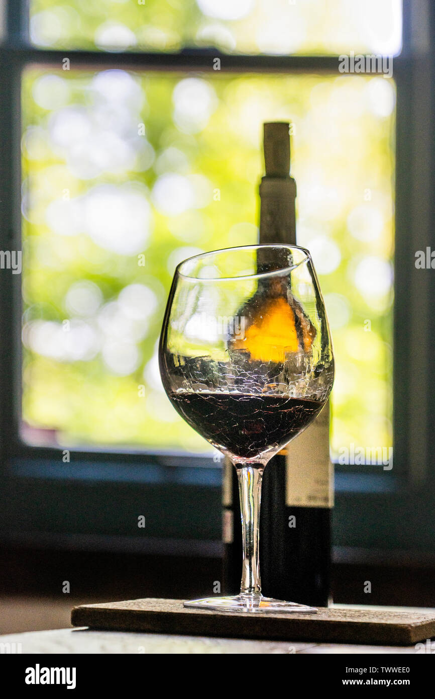 a bottle of red wine behind a glass of red wine Stock Photo