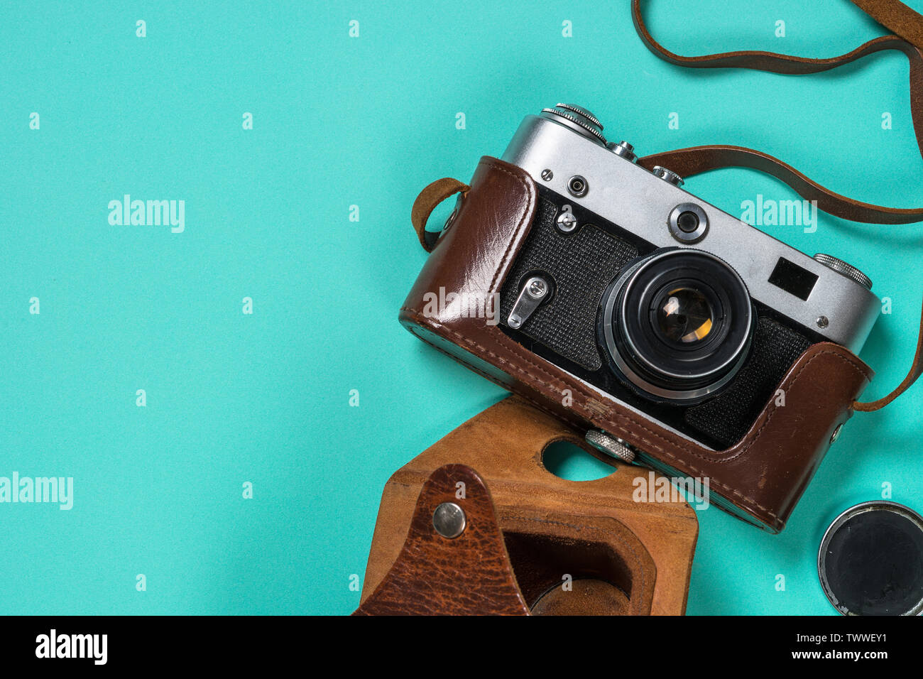 Old film camera on turquoise background. Stock Photo