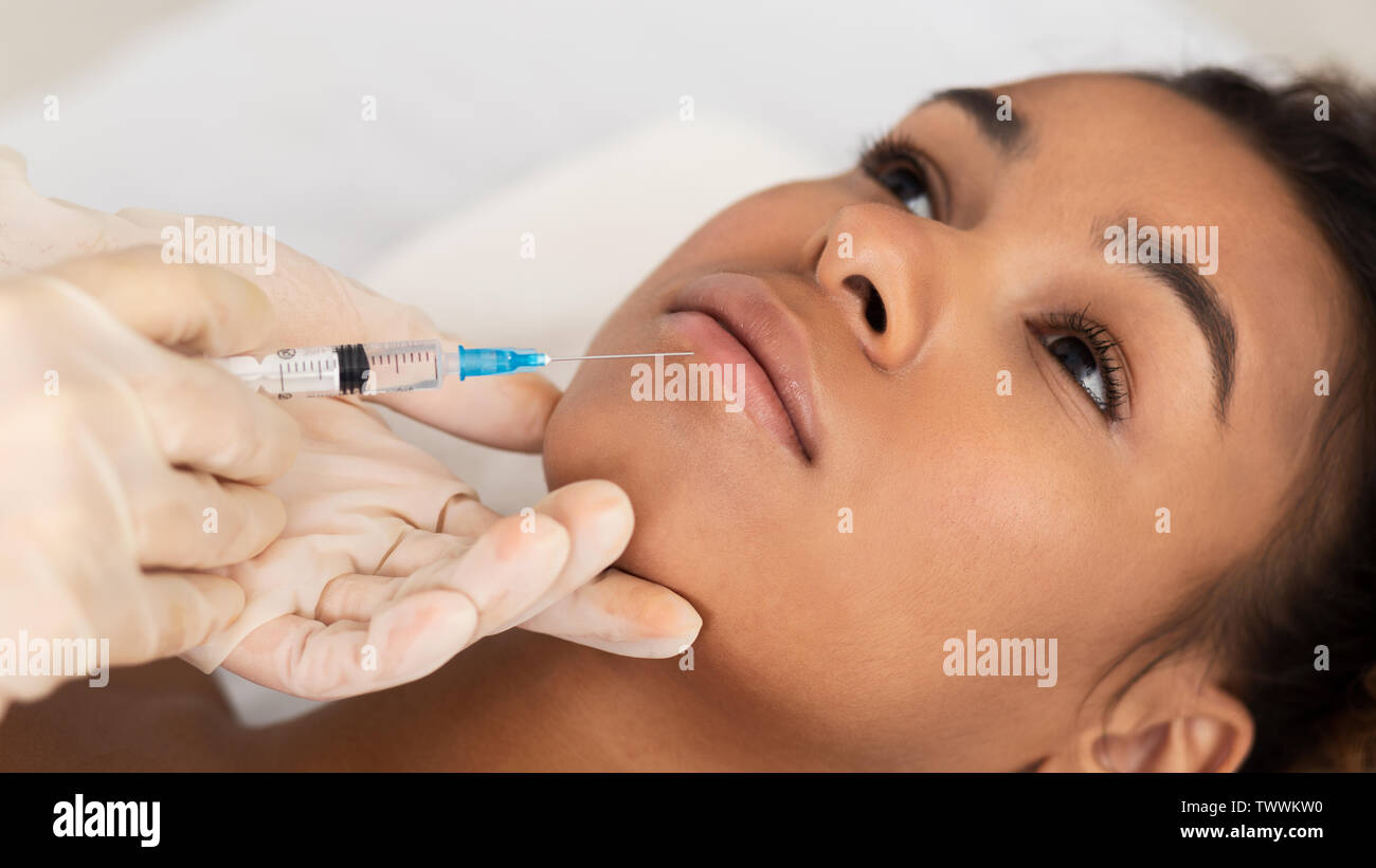 Lip Augmentation. Afro Woman Receiving Hyaluronic Acid Injection Stock Photo