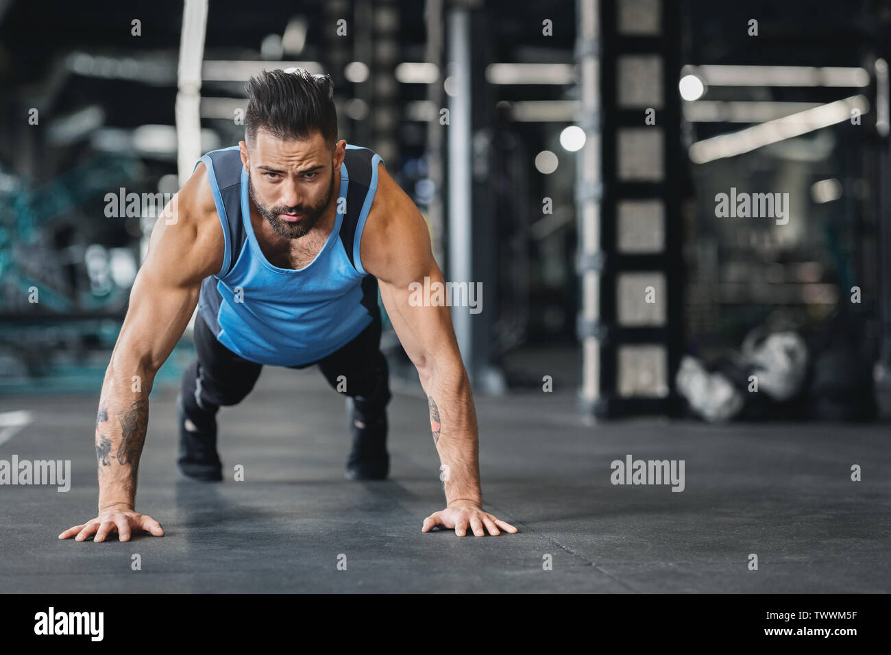Concentrated muscular guy doing push up exercises Stock Photo