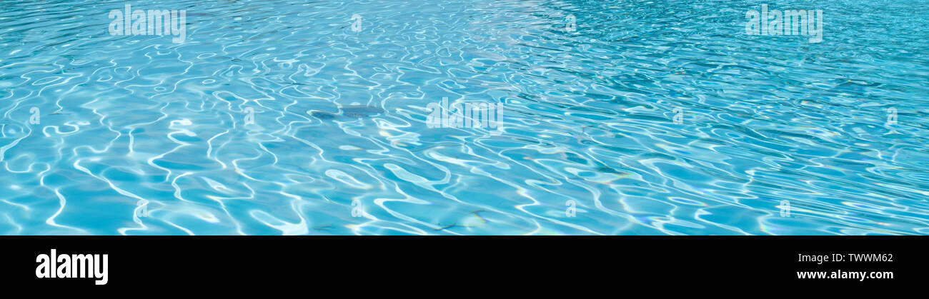 Surface of turquoise water in a swimming pool. Summer time texture background. Stock Photo