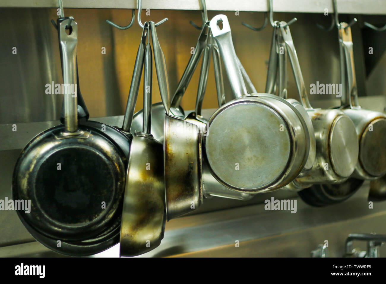 kitchen utensils, pans and pots hanging with hooks Stock Photo - Alamy