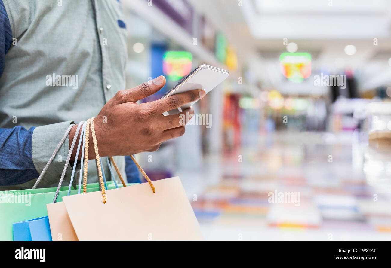 Young man searching new clothes through cellphone online Stock Photo