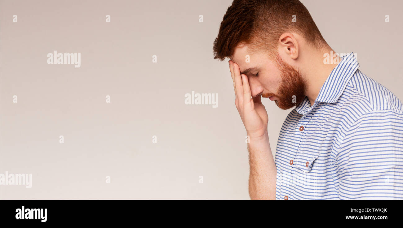 Young disappointed guy covering face with hand Stock Photo