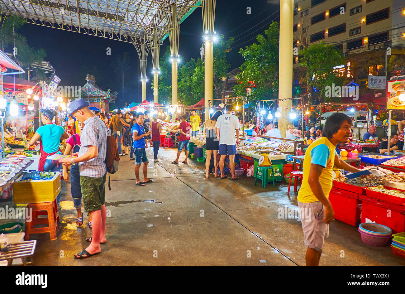PATONG, THAILAND - MAY 1, 2019: Walk along the crowded alleyway of Banzaan Night Bazaar, choose some tasty local foods, drinks or Phuket souvenirs, on Stock Photo