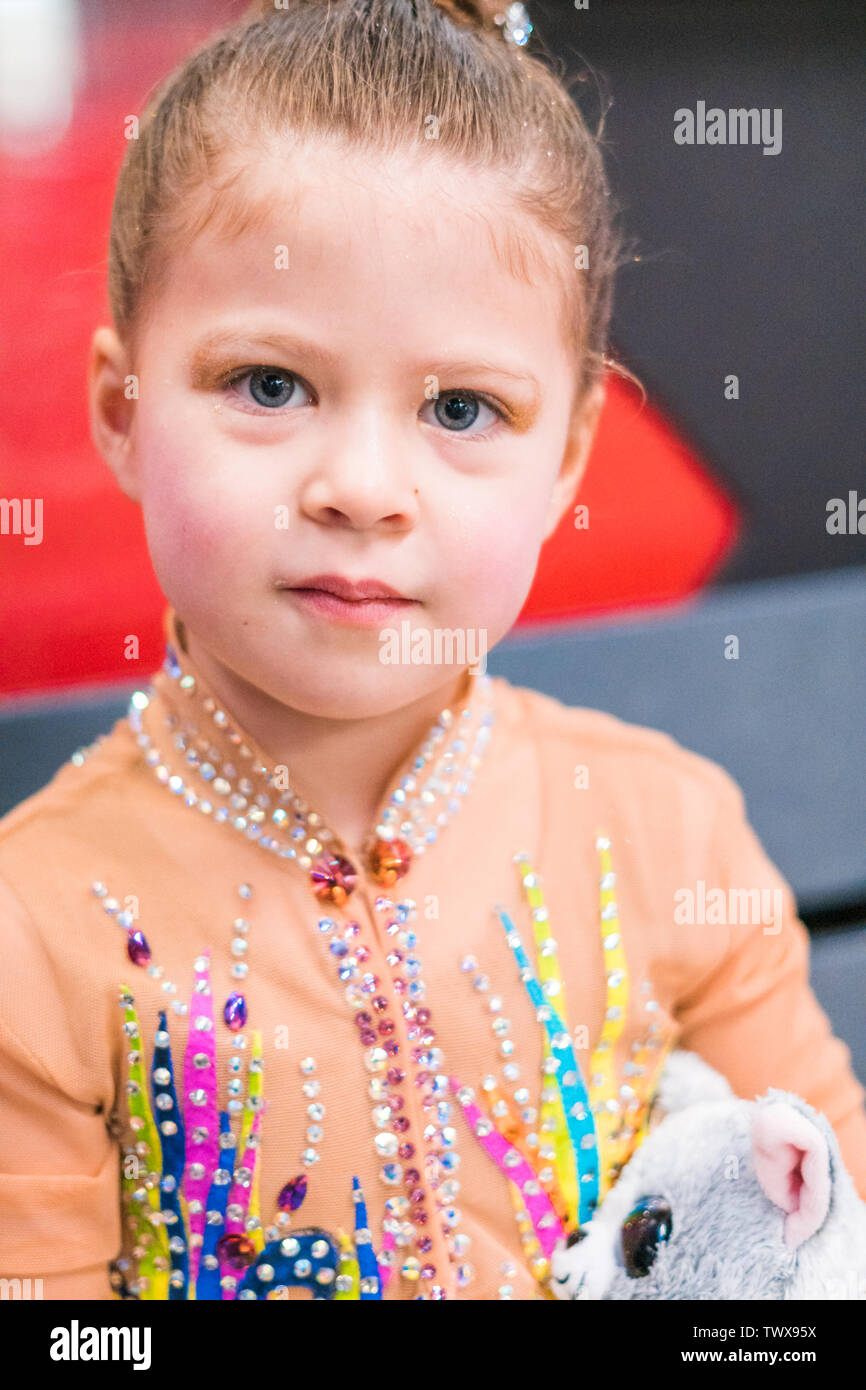 Little girl practicing for figure skating competition on indoor