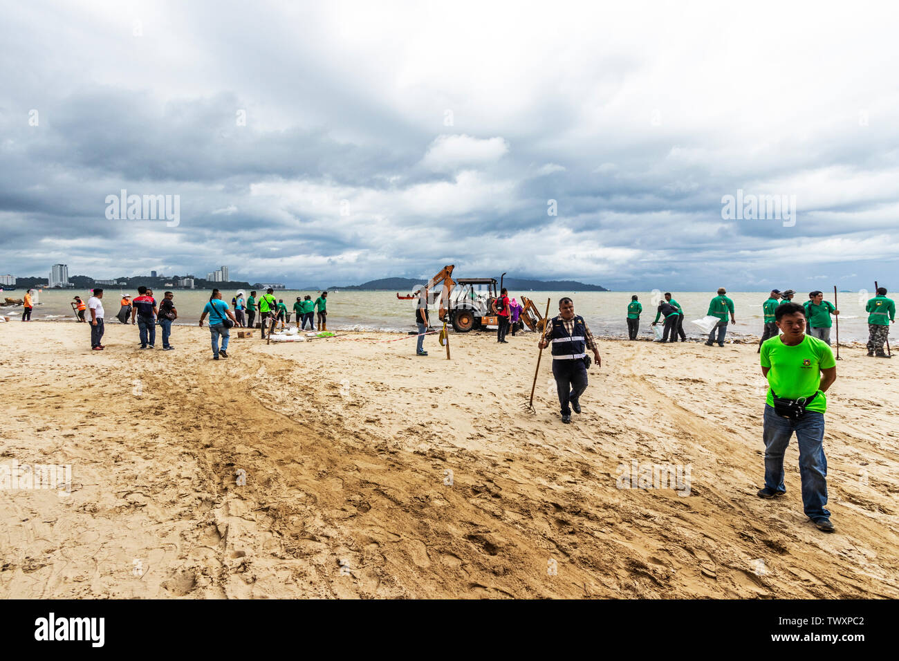 Workers cleaning up the beach at Likas Bay Kota Kinabalu Sabah Malaysia ...