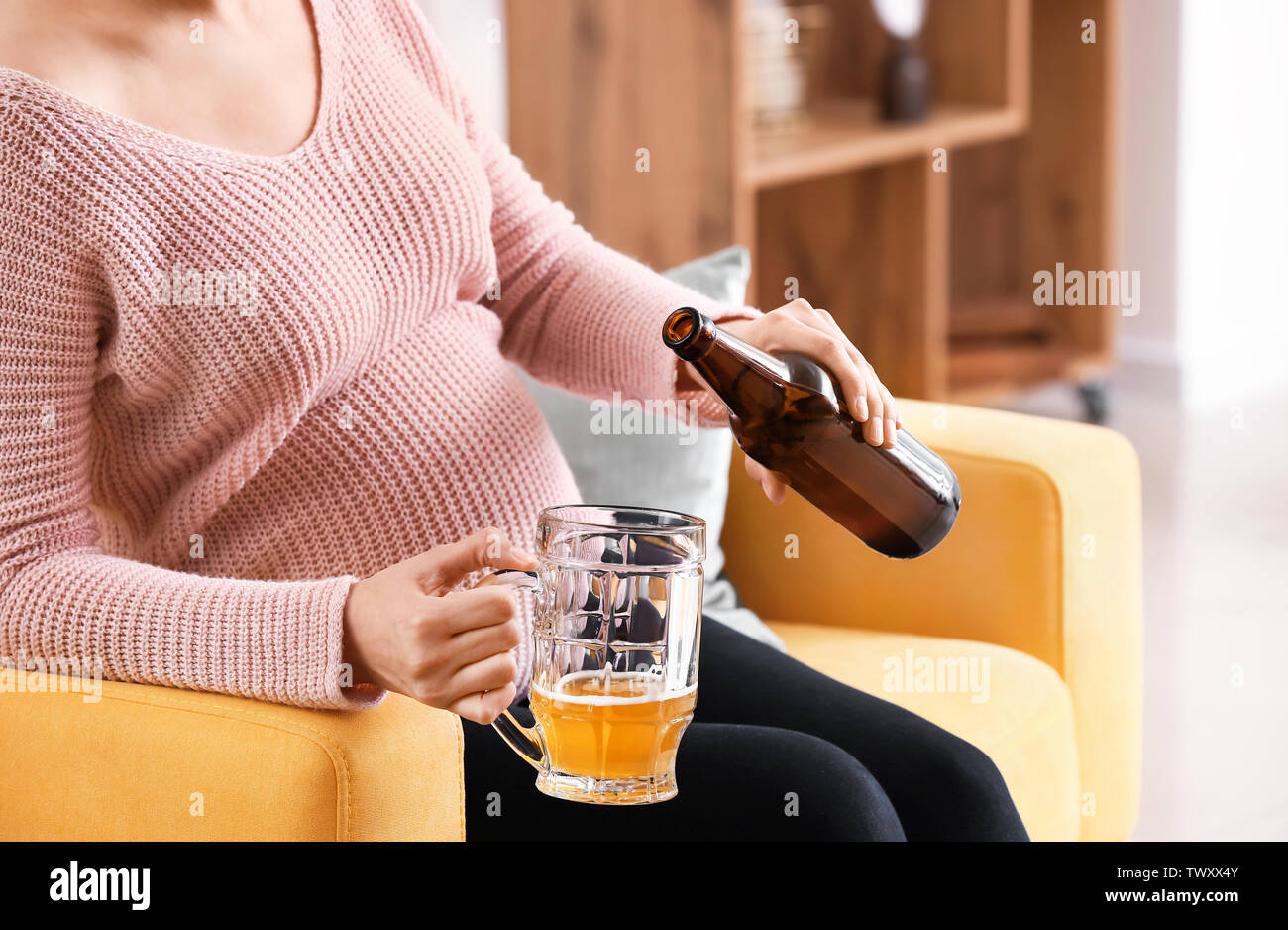 Pregnant woman drinking beer at home Stock Photo Alamy