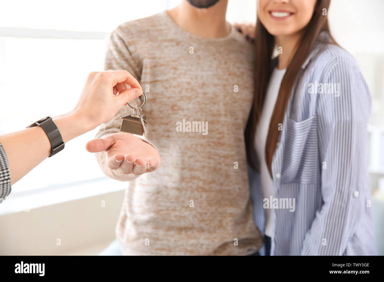 Real estate agent giving a keys from new house to young couple Stock ...