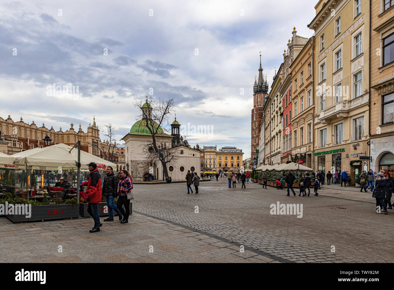Cracow, Poland – Feb 2, 2019: Tourists at main square passing by The Church of St. Adalbert or of St. Wojciech, the 11th century church in Cracow, Pol Stock Photo