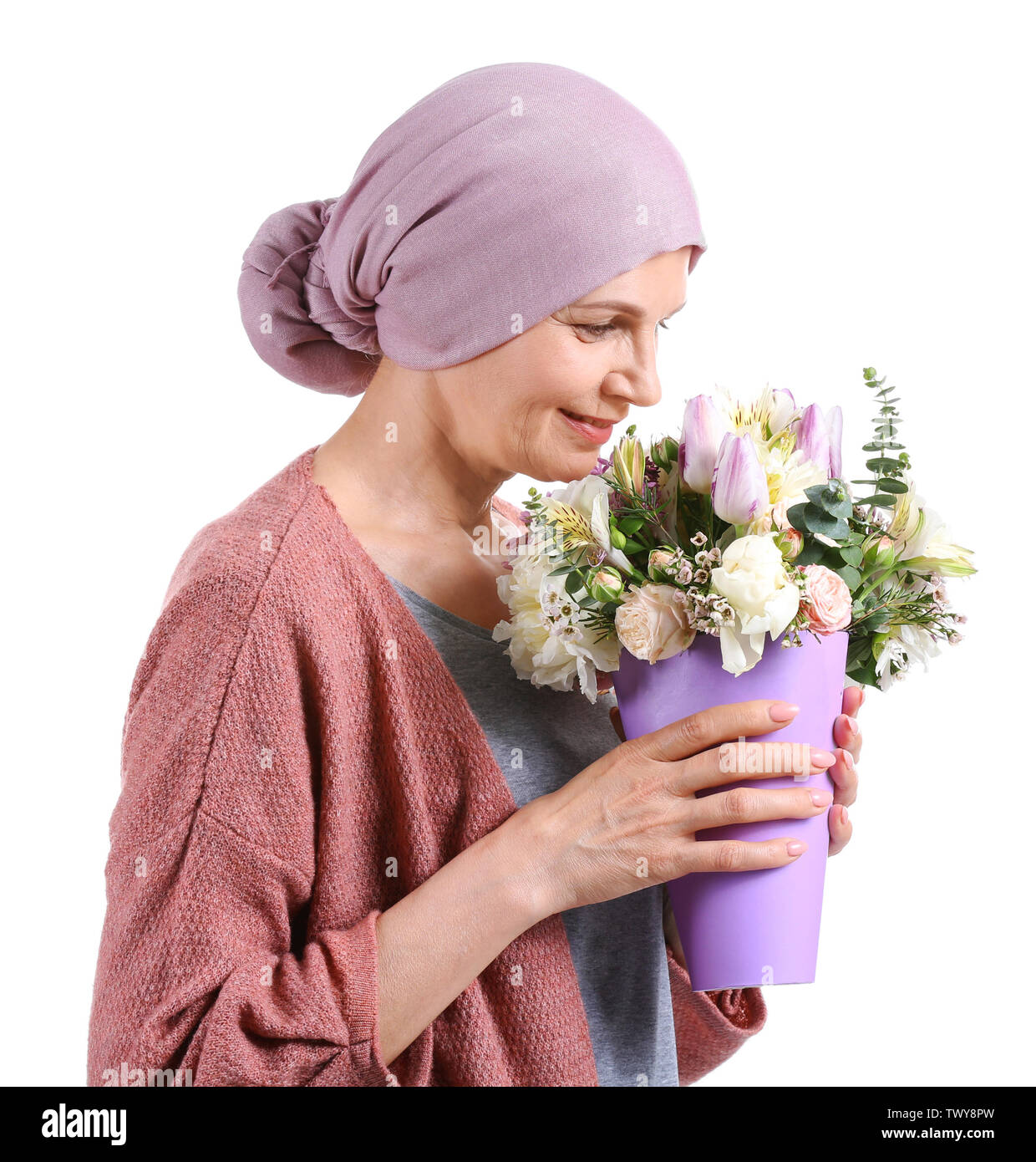 Mature woman after chemotherapy with bouquet of flowers on white