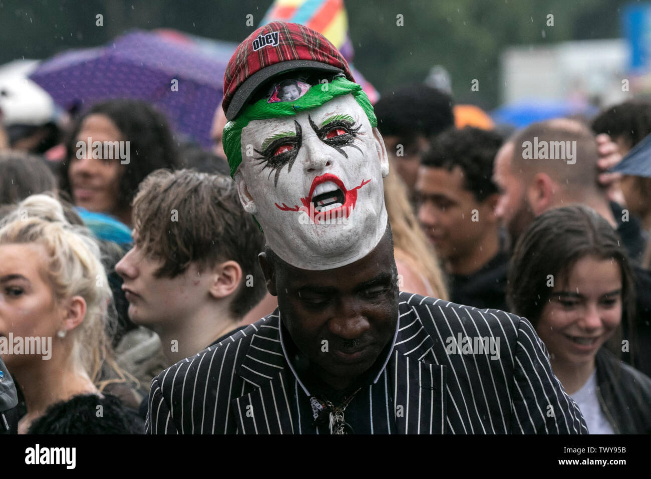 A man wears a joker mask from the hollywood batman movie franchise Stock Photo