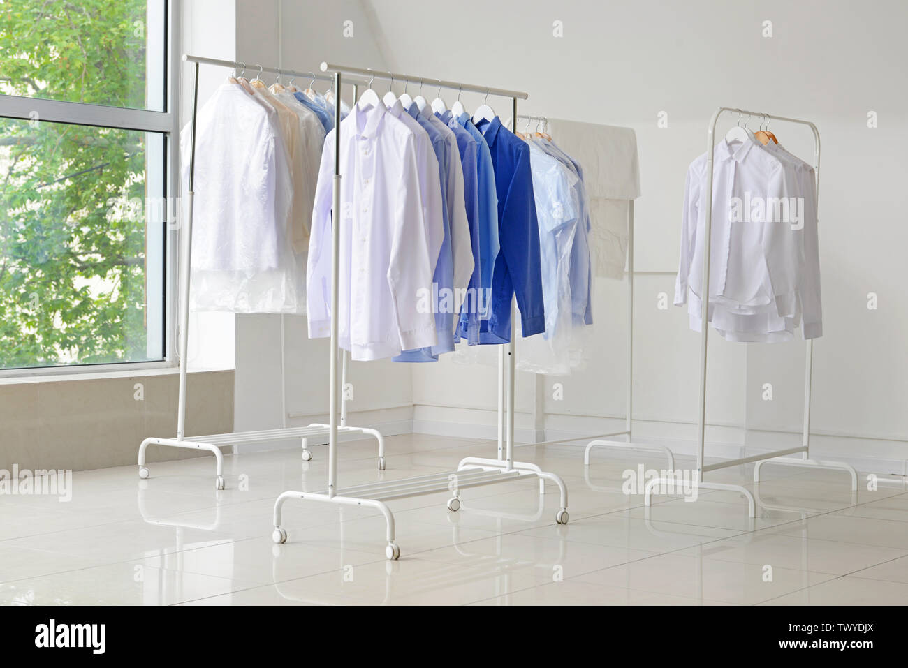 Racks with clothes after drycleaning indoors Stock Photo Alamy