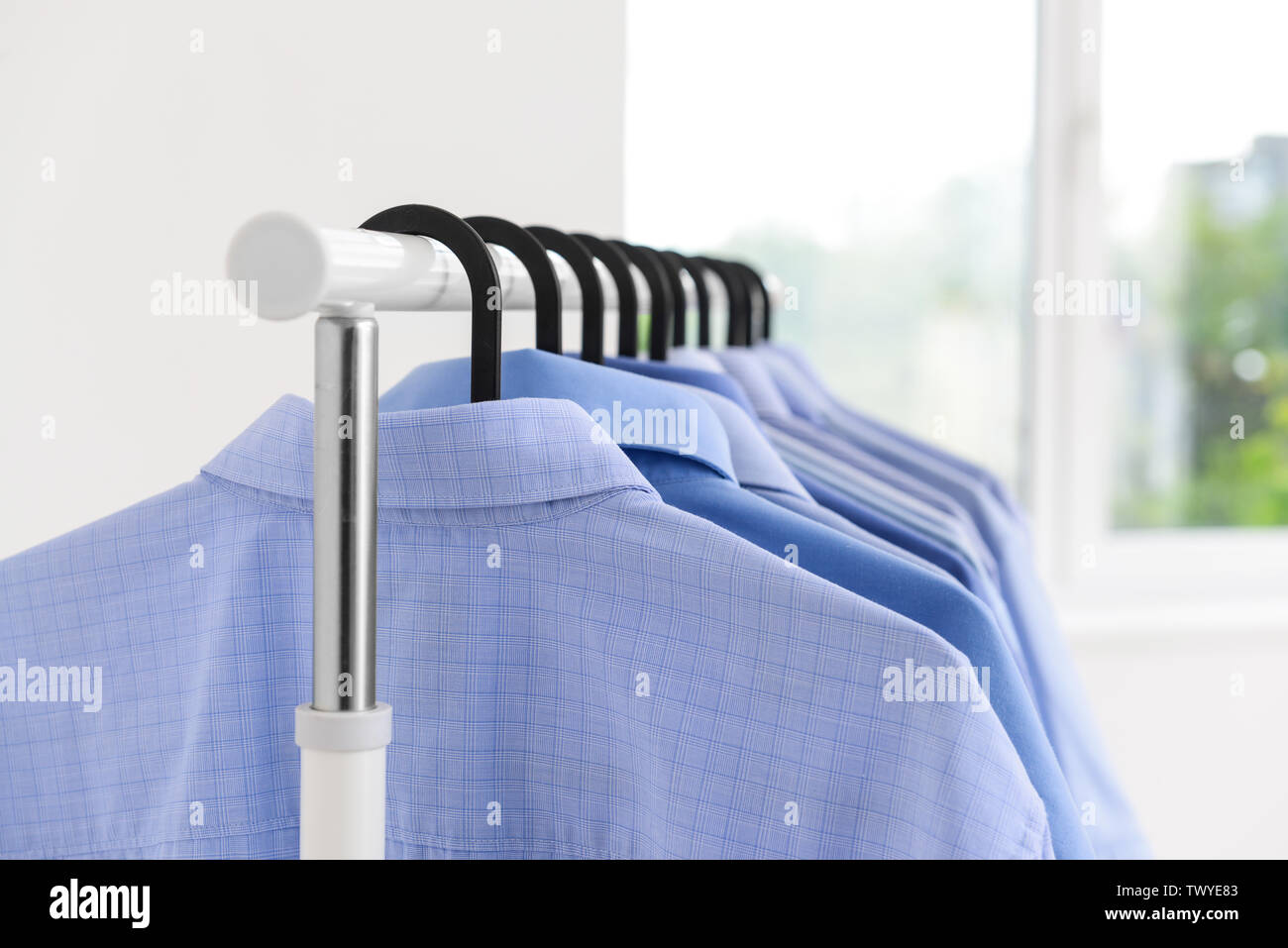 Concept of dry cleaning service. Hangers with clean clothes hanging on rack  Stock Photo - Alamy