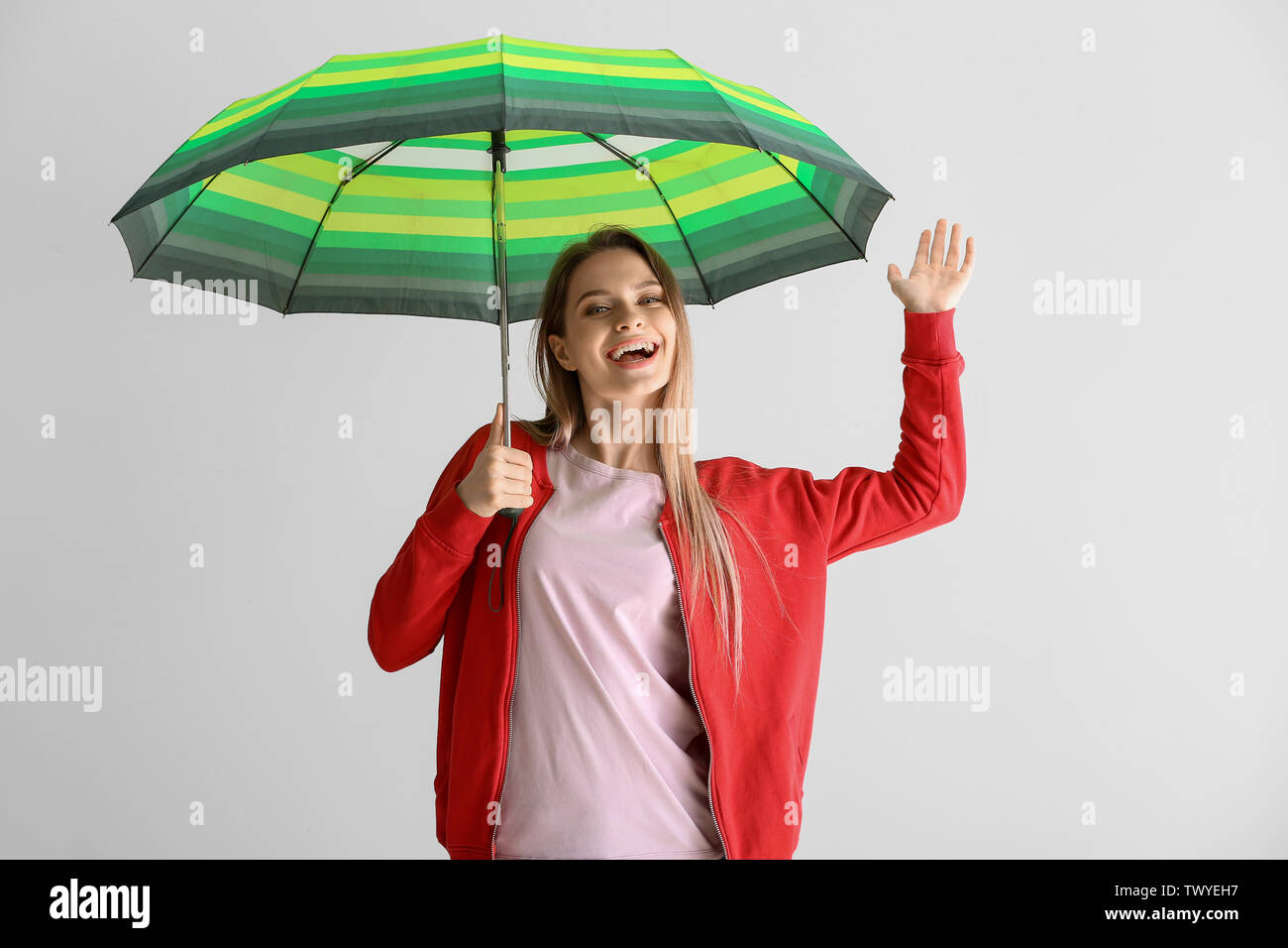 Beautiful young woman with umbrella on white background Stock Photo - Alamy