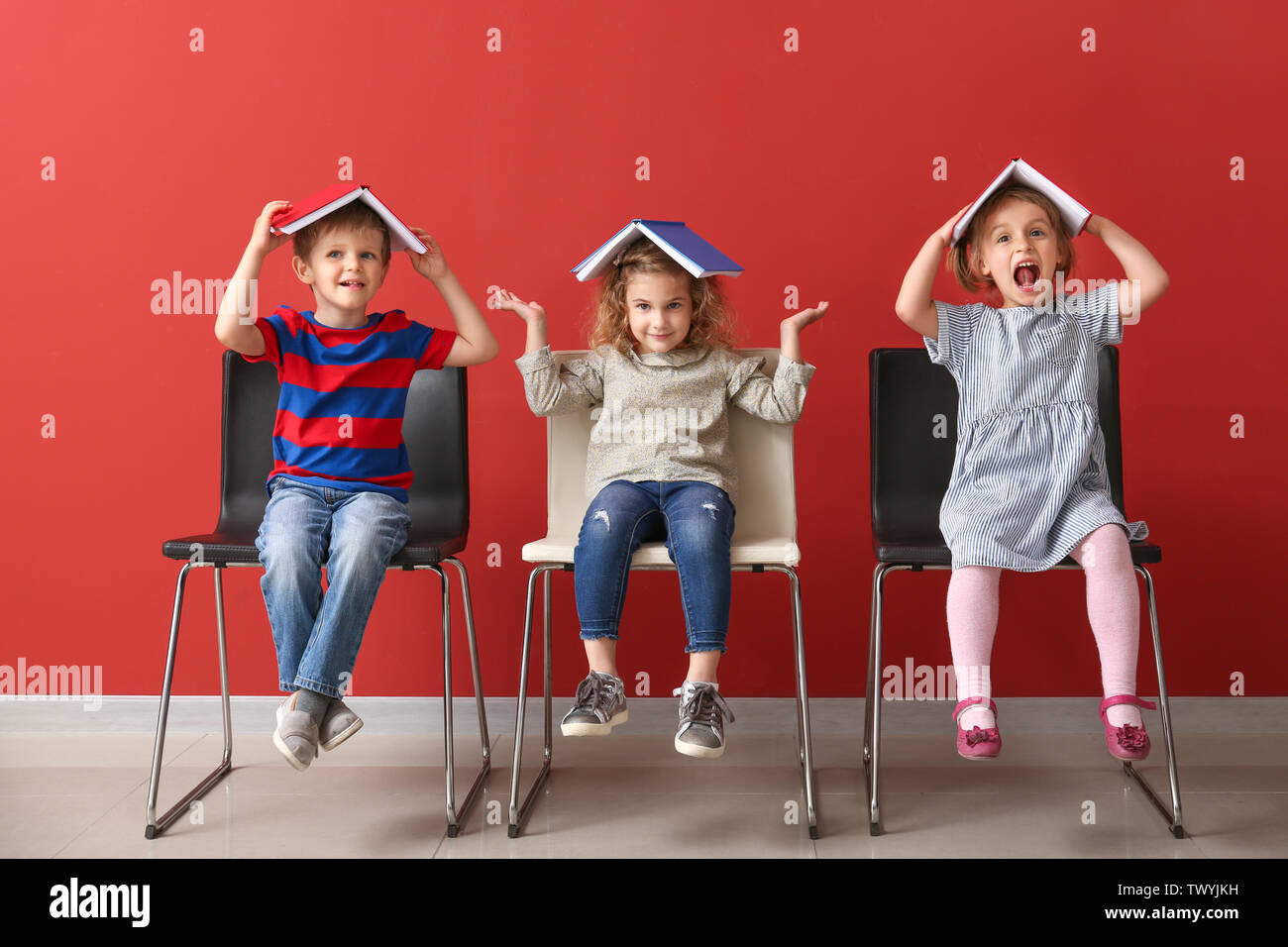 Cute little children with books near color wall Stock Photo Alamy