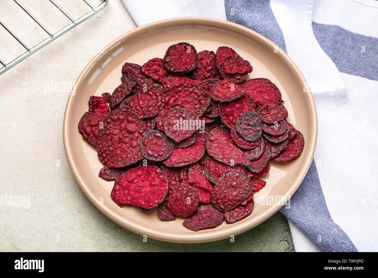 Plate with tasty beet chips on table Stock Photo