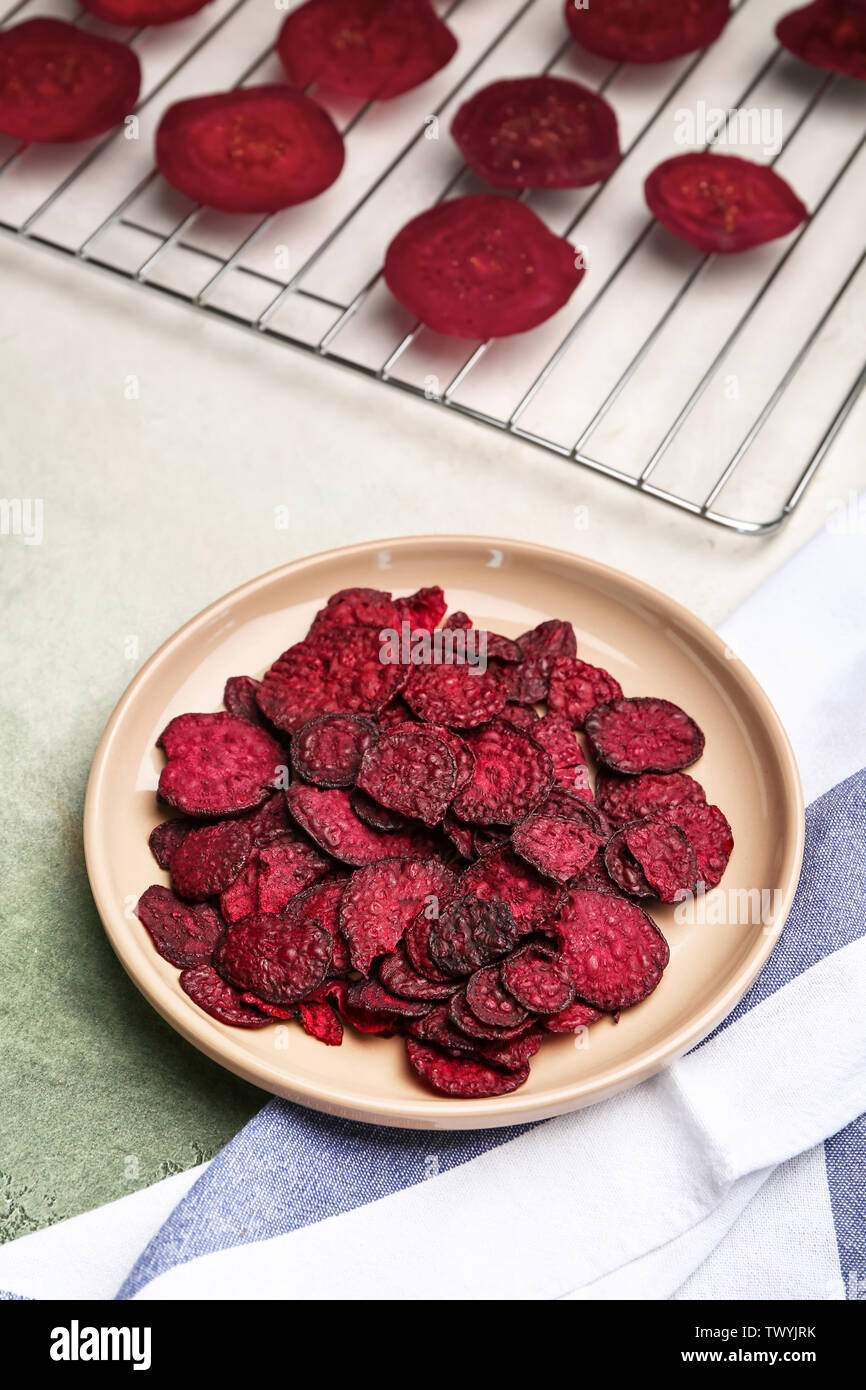 Plate with tasty beet chips on table Stock Photo