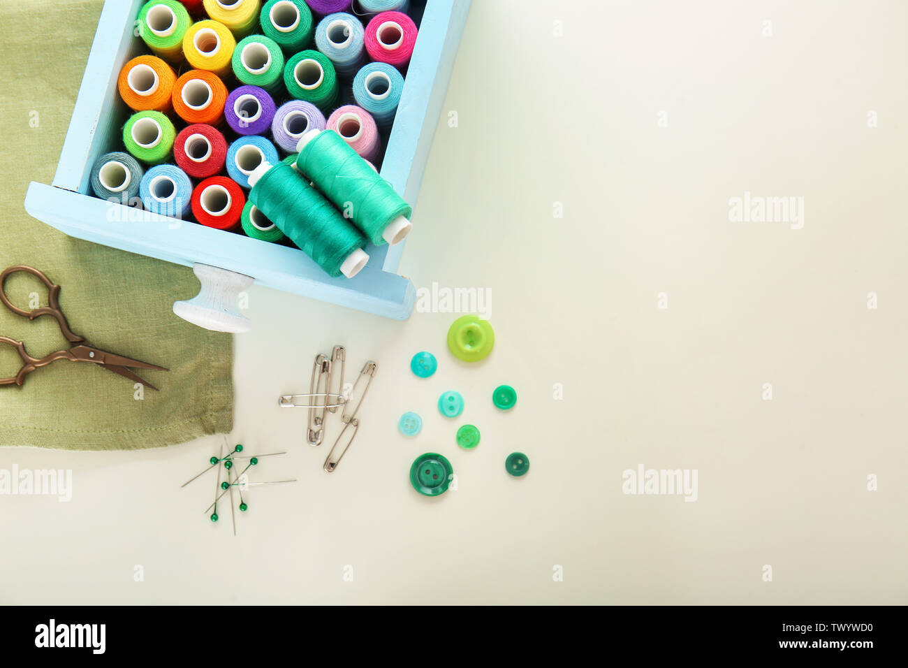 Box with colorful sewing threads on light background Stock Photo - Alamy