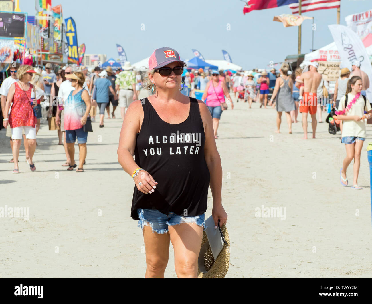A mature woman wearing a black tank top with the words, 'Alcohol You Later,' on front. 2019 Texas Sandfest Port Aransas, Texas USA. Stock Photo