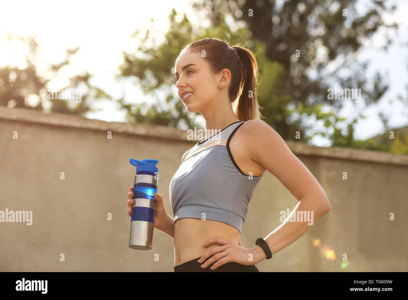 Sporty young woman with bottle of water outdoors Stock Photo - Alamy