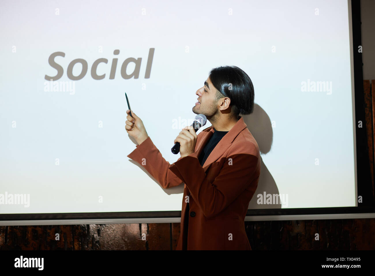 Waist up portrait of young middle-eastern businessman giving speech on social media marketing at conference, copy space Stock Photo