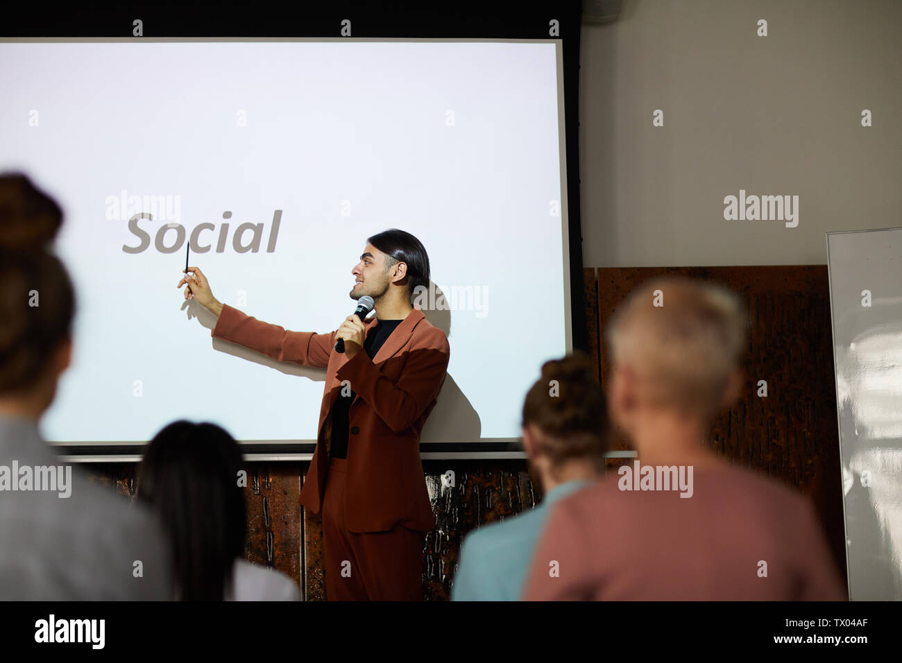 Side view portrait of young middle-eastern businessman giving speech on social media marketing at conference, copy space Stock Photo