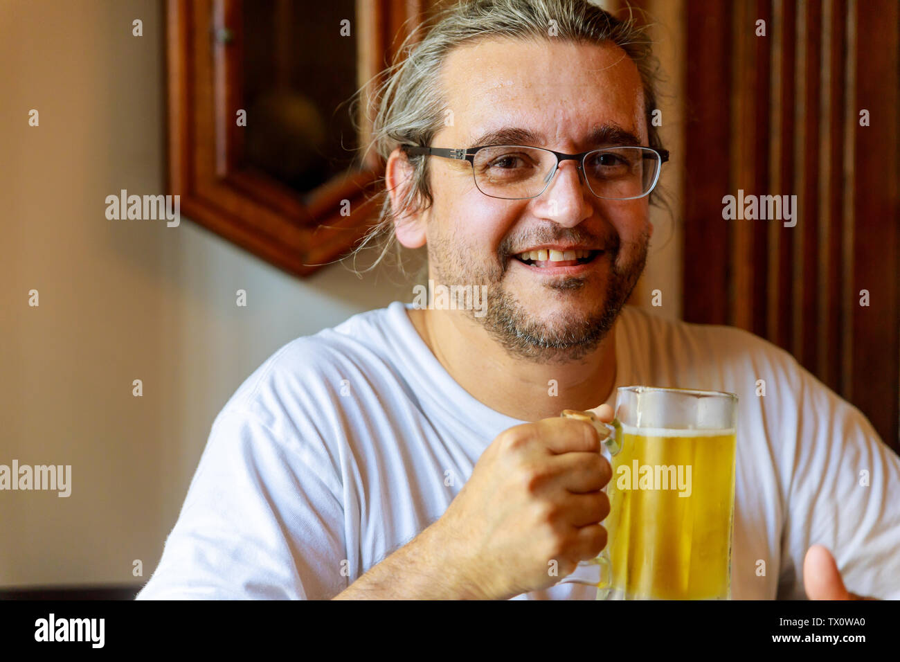 Man drinking beer Side view of handsome man drinking beer while sitting