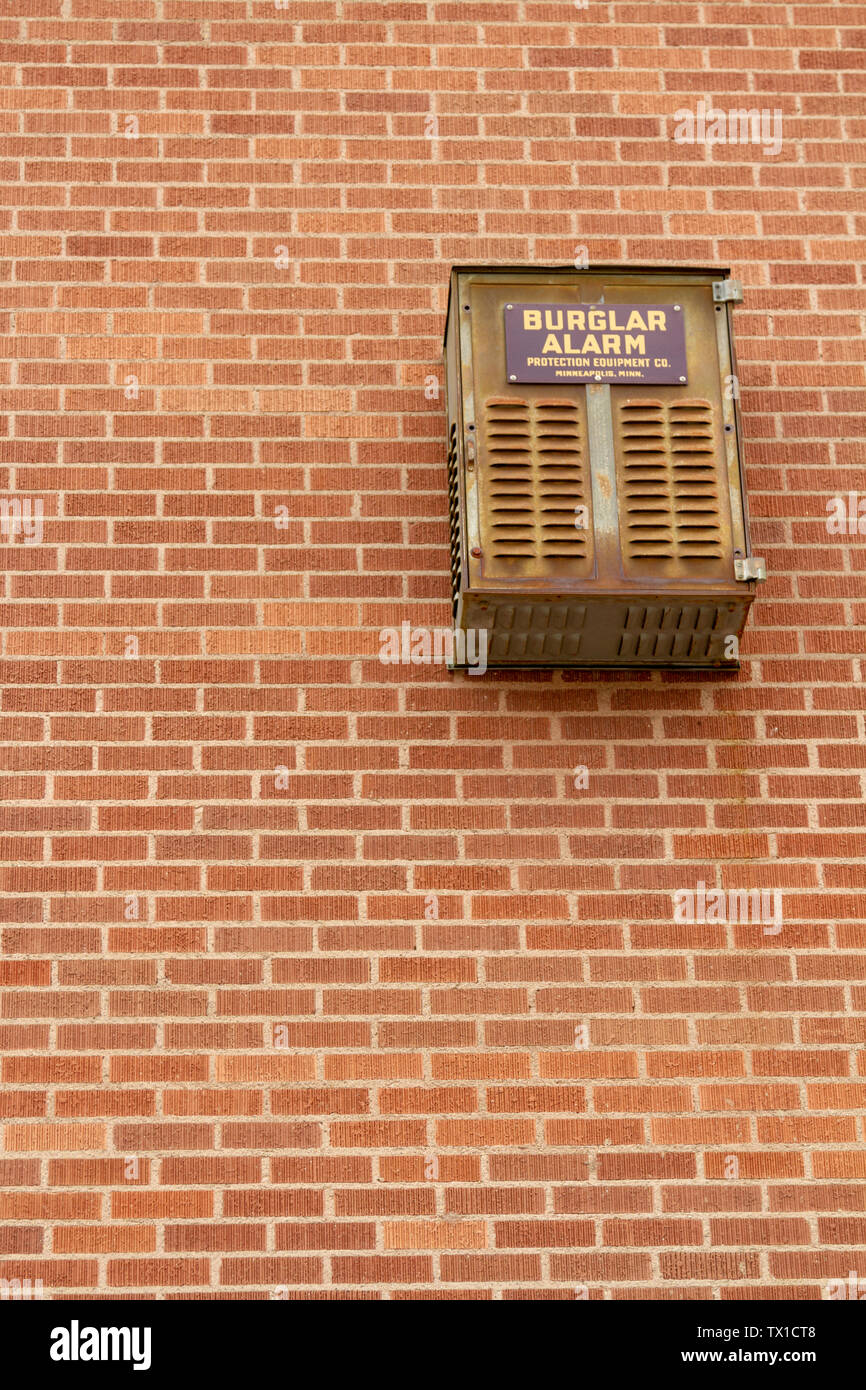 An out dated burglar alarm, made by Protection Equipment Co., hangs on the exterior of a brick building in downtown Helena, Montana, USA. Stock Photo