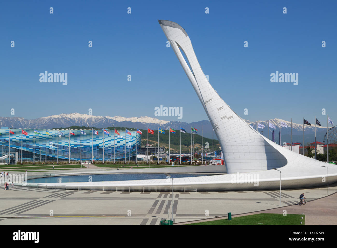 SOCHI, KRASNODAR REGION, RUSSIA, MAY 01, 2017:  The Olympic Flame Bowl against the backdrop of stadium the Iceberg Skating Palace and snow-capped moun Stock Photo