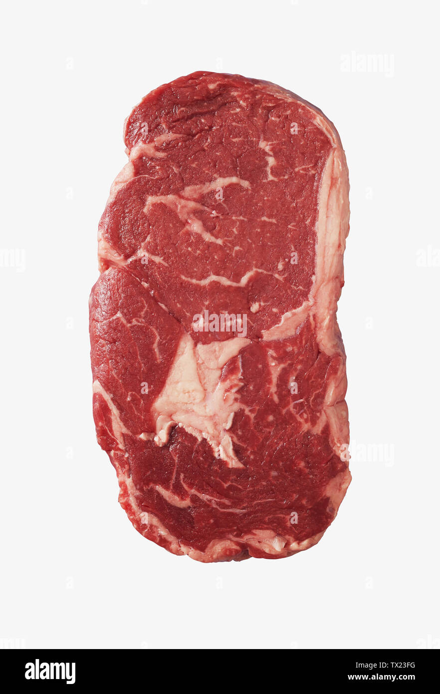 Slab of thick raw rib eye beef steak with marbled fat isolated on white