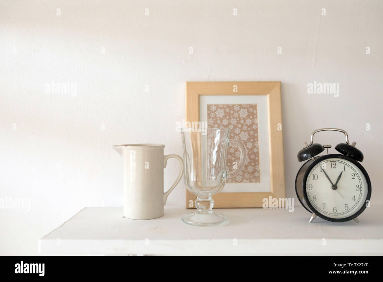 Black alarm clock vase and glass on table Stock Photo