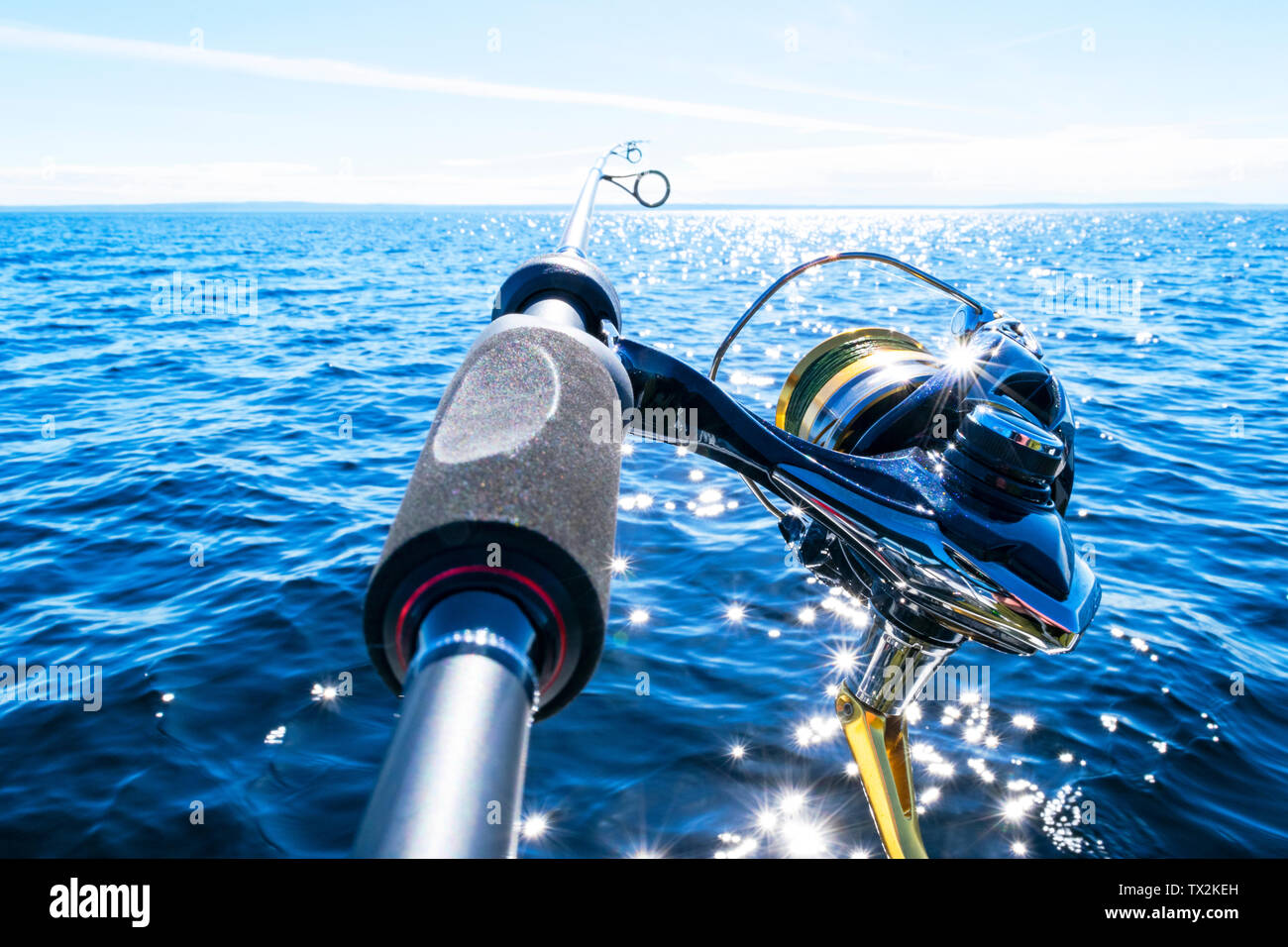 Fishing rod spinning with the line close-up. Fishing rod in rod holder in fishing boat due the fishery day. Fishing rod rings. Fishing tackle. Fishing Stock Photo