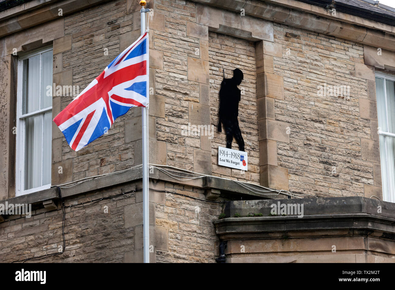 Silhouette of a WW1 Soldier with a Royal British Legion Lest we Forget Sign and Union Jack Flag, Barnard Castle, County Durham, UK. Stock Photo