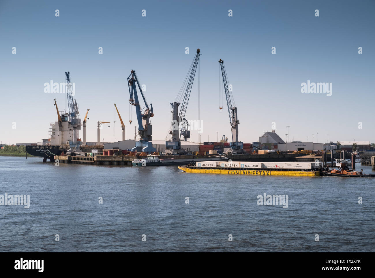 A container taxi transports large containers along the Elbe river, Hamburg, Germany. Stock Photo