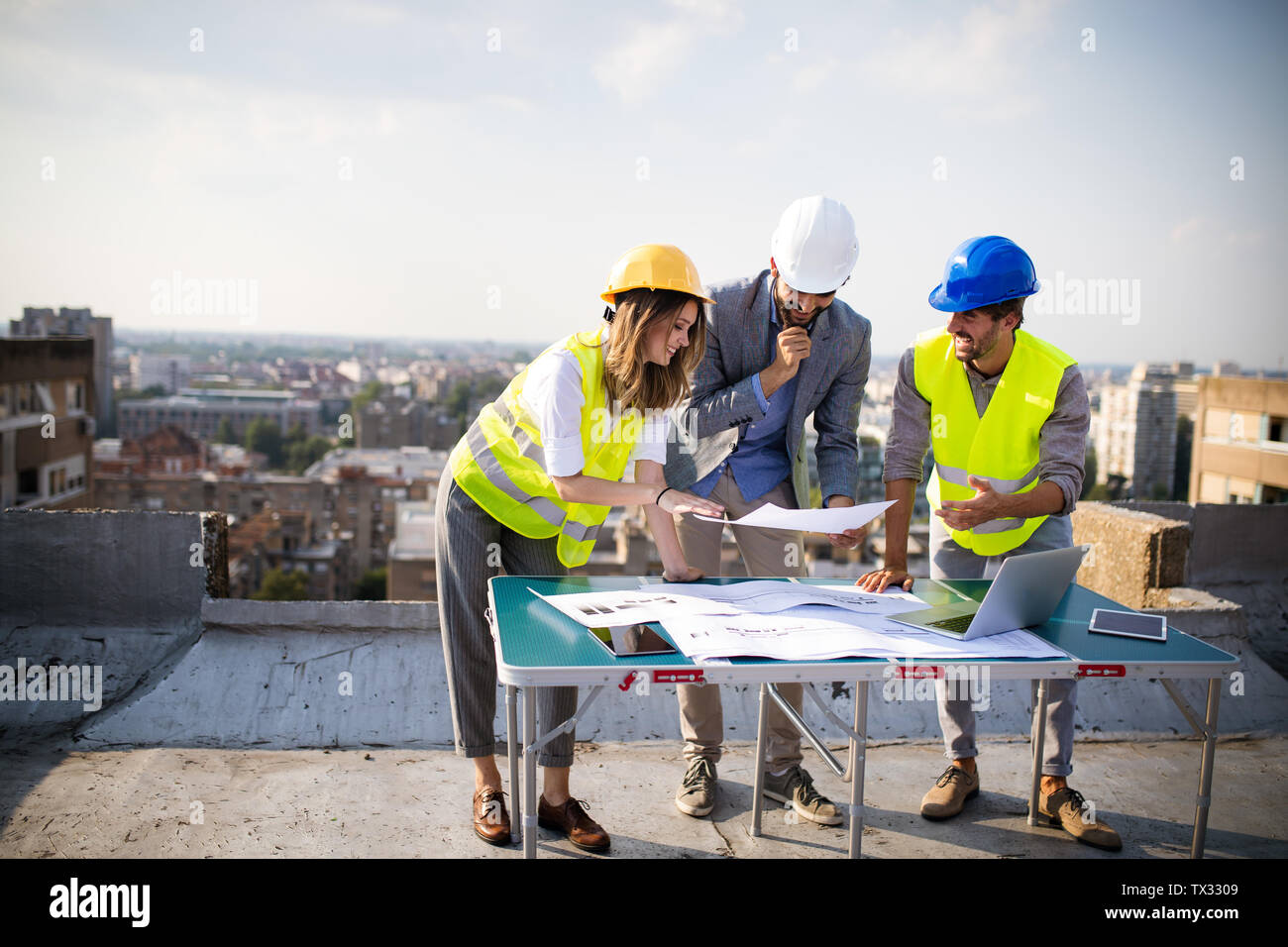 Architects team and engineers looking paper plans at construction site. Stock Photo
