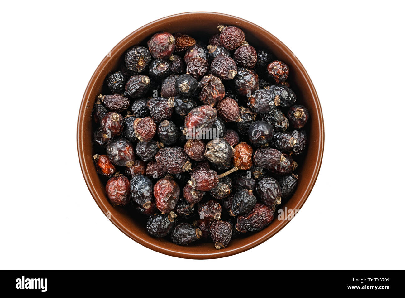 Dried rose hips in wooden bowl. File contains clipping path Stock Photo