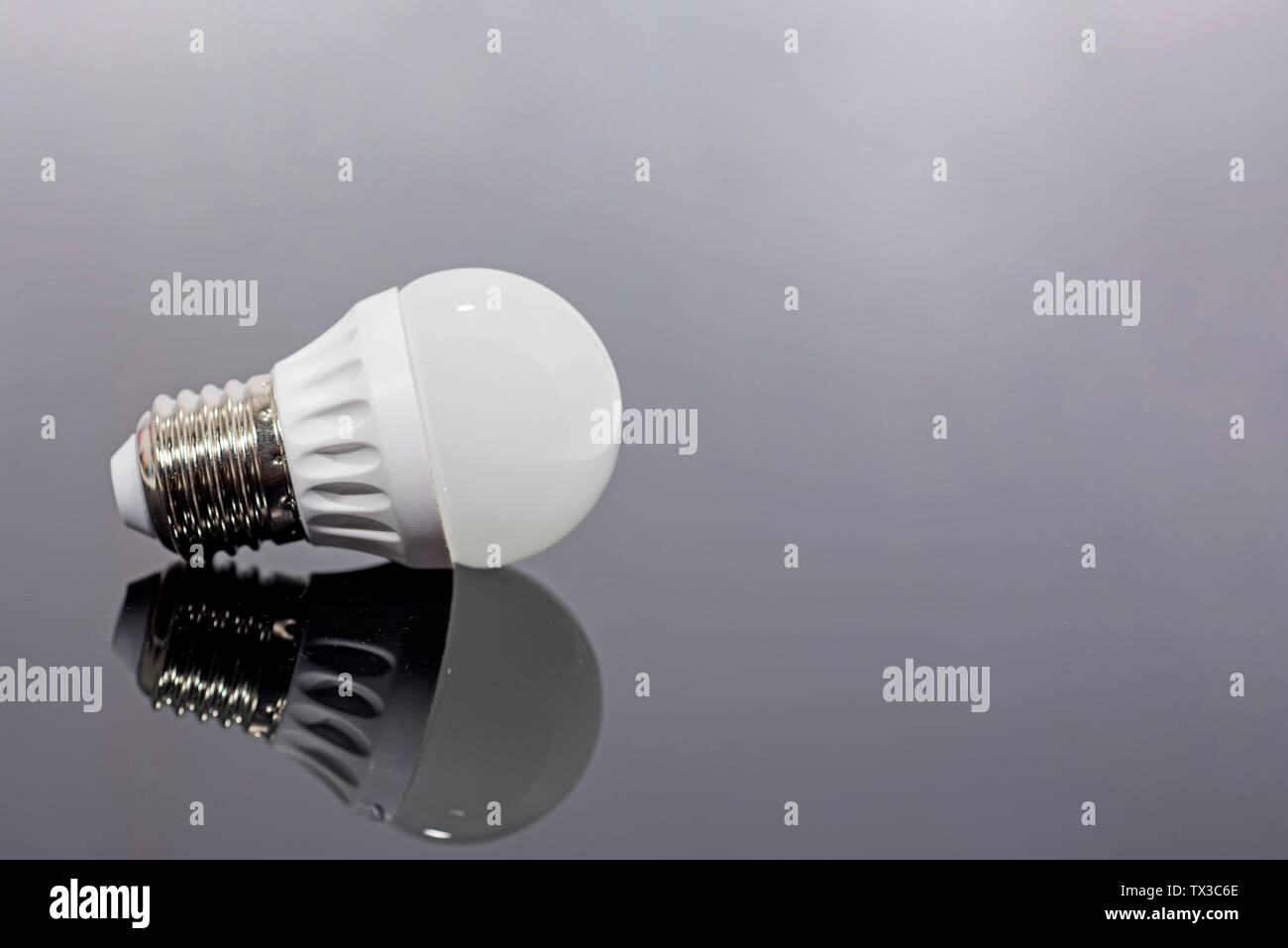 Modern LED lamp on a dark mirror background. Stock Photo