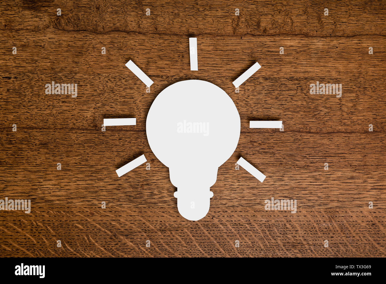 View from above paper light bulb on wooden surface Stock Photo