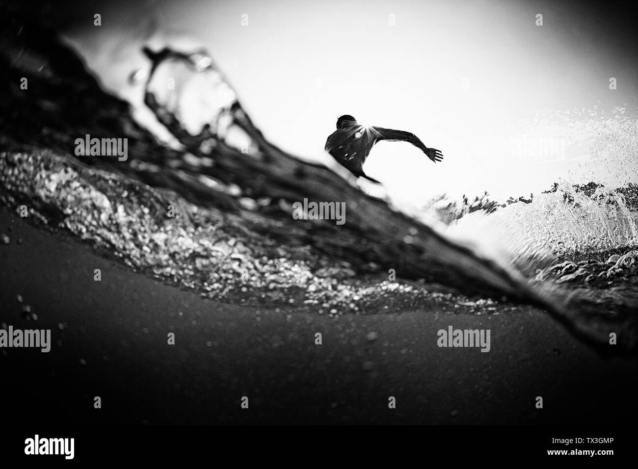 Male surfer making cutback from behind ocean wave Stock Photo