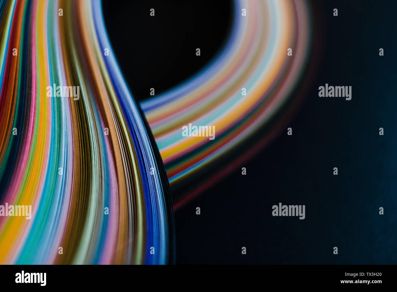 Abstract rainbow paper wave pattern on black background Stock Photo
