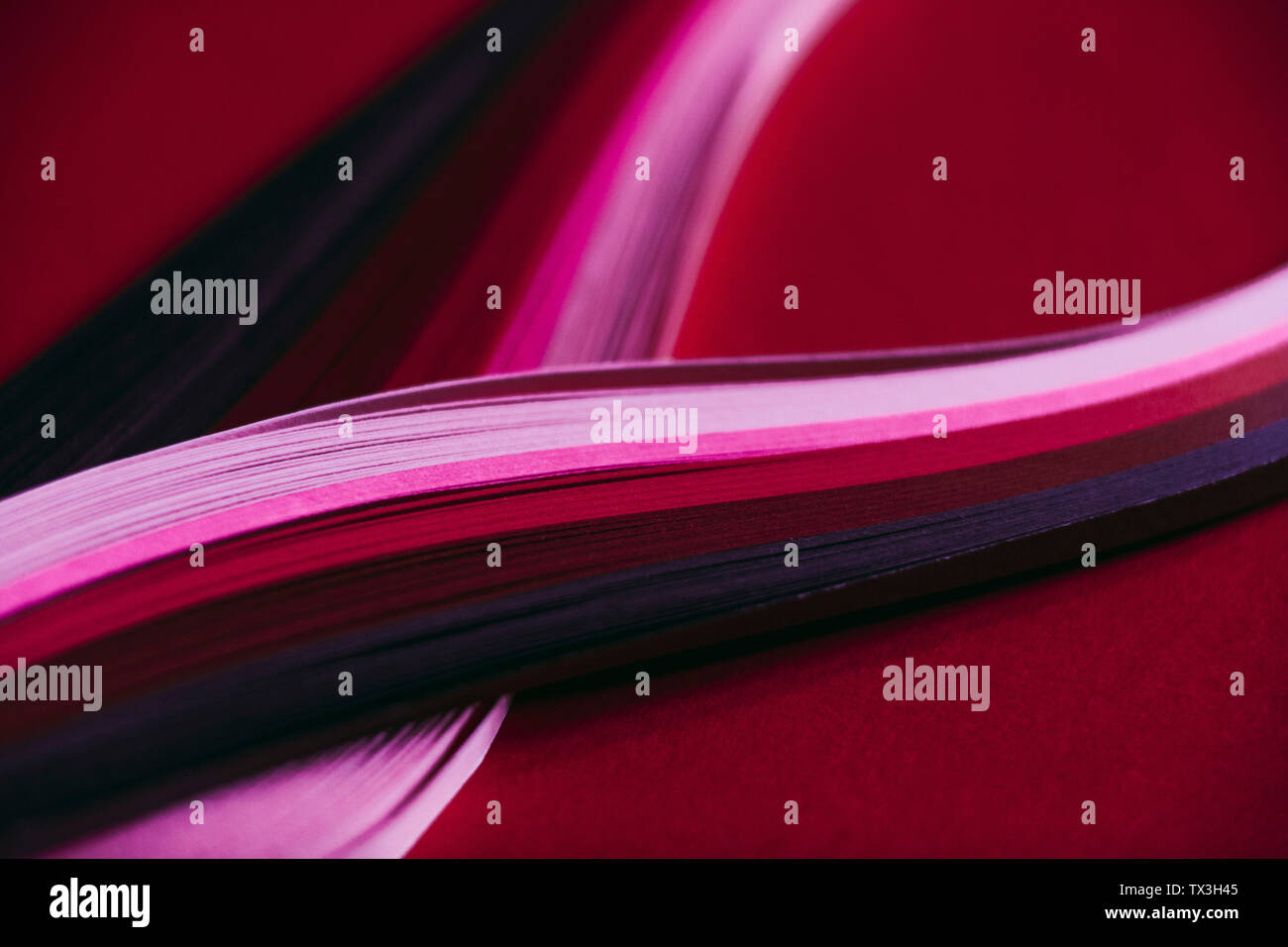 Abstract rainbow paper wave pattern on red background Stock Photo